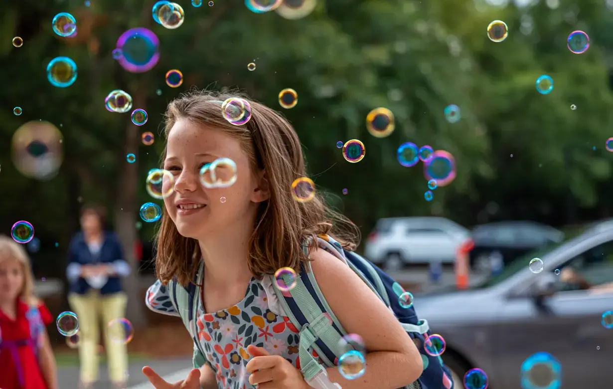 Lower school student surrounded by bubbles