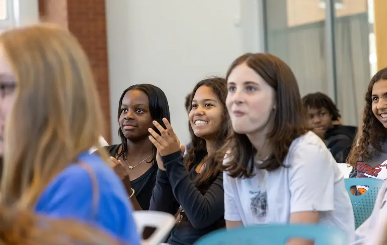 Group of middle school students smiling and clapping