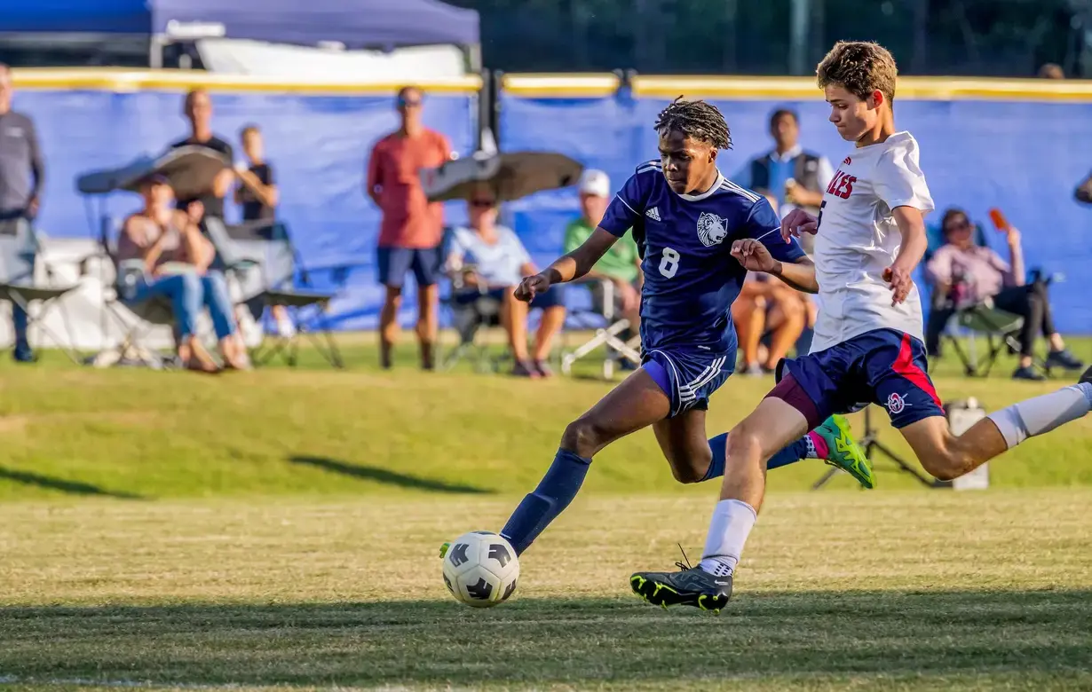 Male students playing soccer