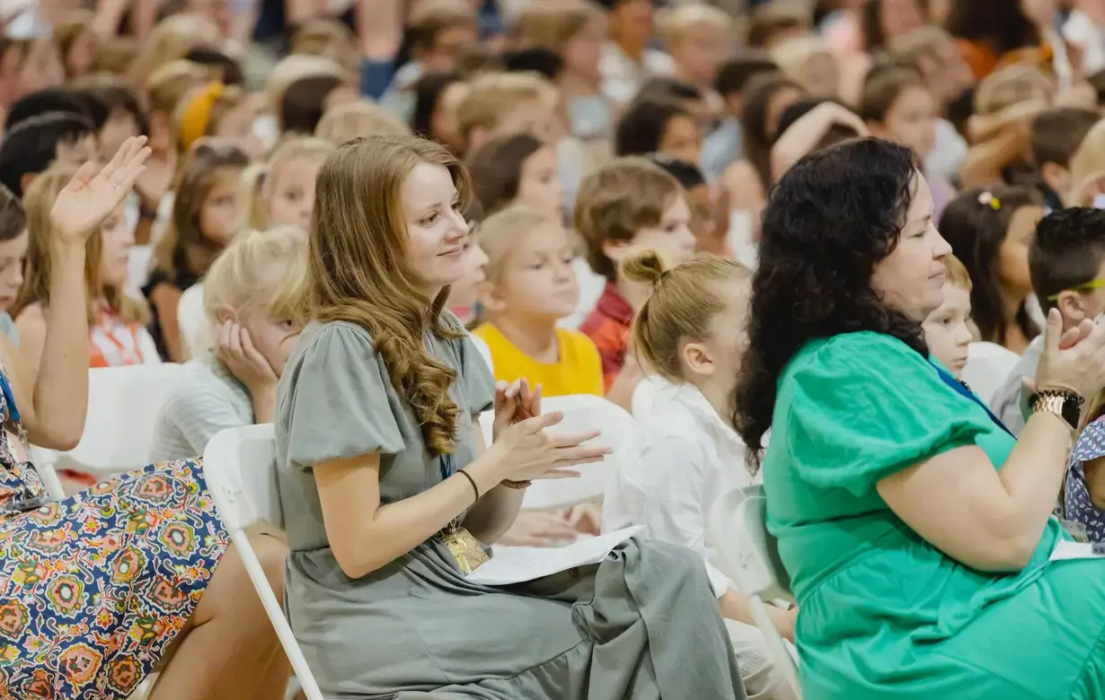 Member of Trinity School faculty clapping during assembly