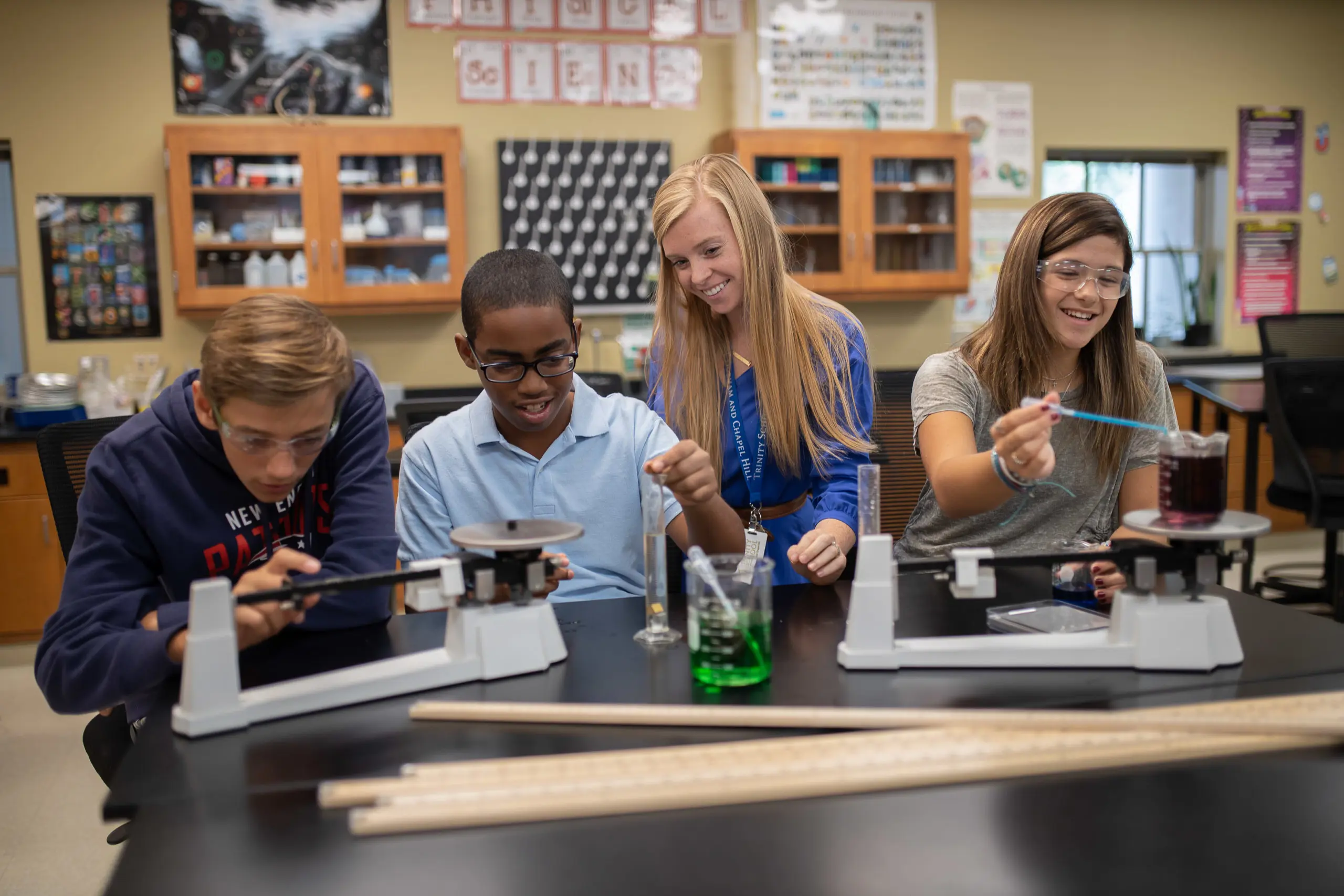 Trinity member of staff joyfully engaged in teaching students in the classroom